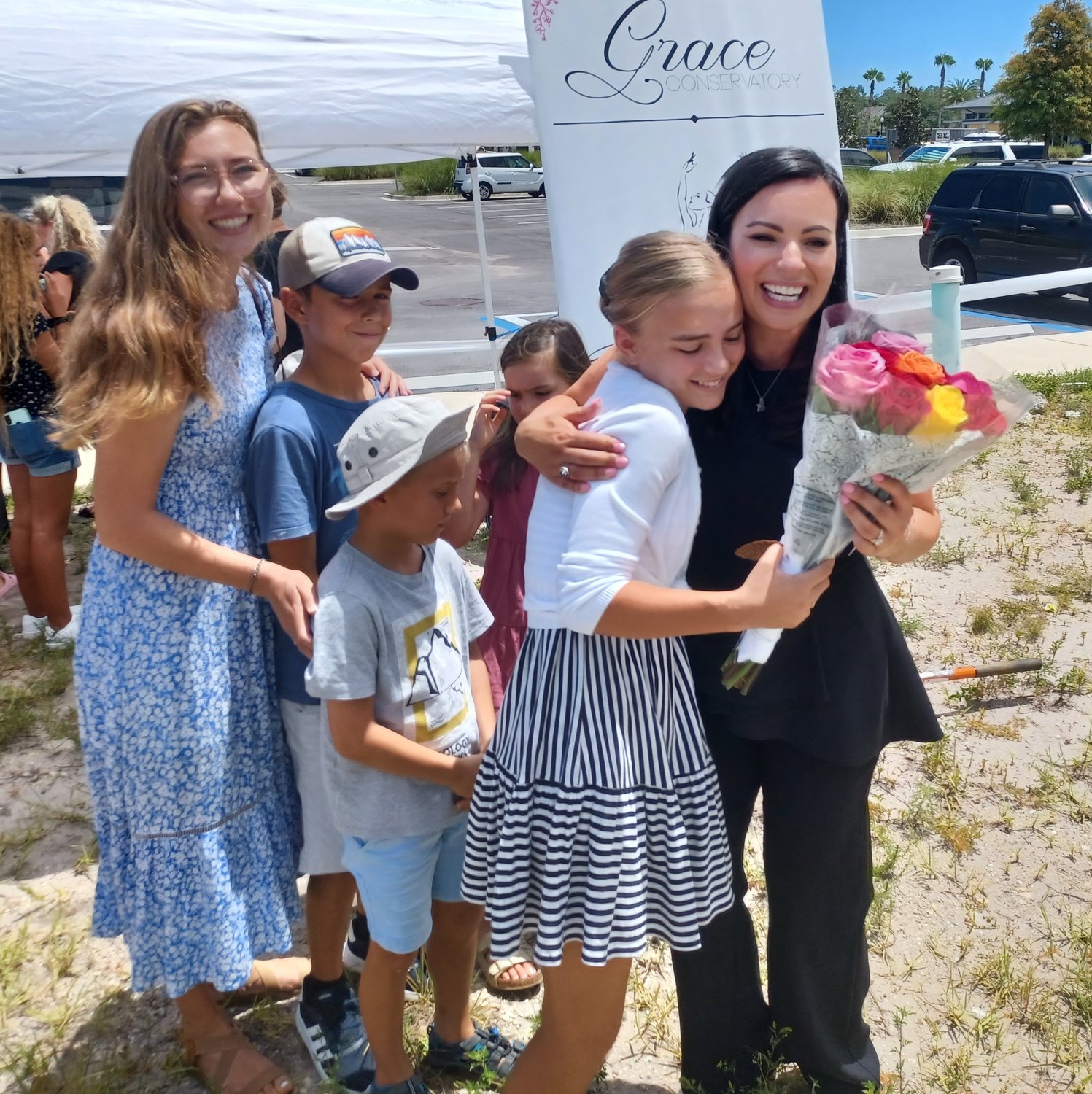 A student presents a bouquet of flowers to Kristina Robison to congratulate her on the groundbreaking for Grace Conservatory’s new dance studio.